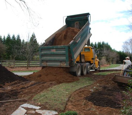 March 16. Perhaps the scariest part of the day was watching 11 yards of screened top soil (clay) being dumped to build up berms on either side of the path. The tractor moved it all into place, but my formerly green grass path was history.
